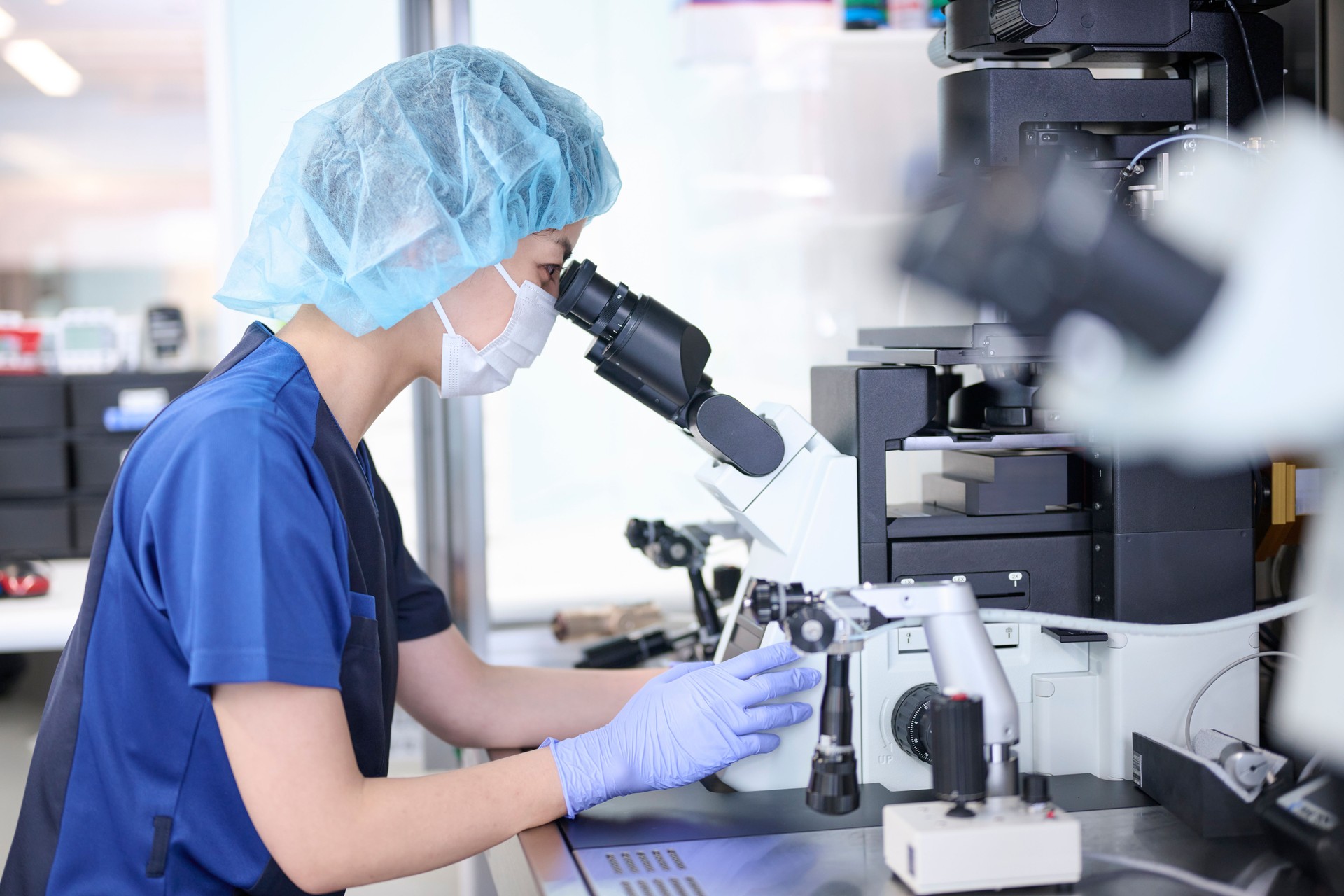 Embryologist using a microscope in the culture room